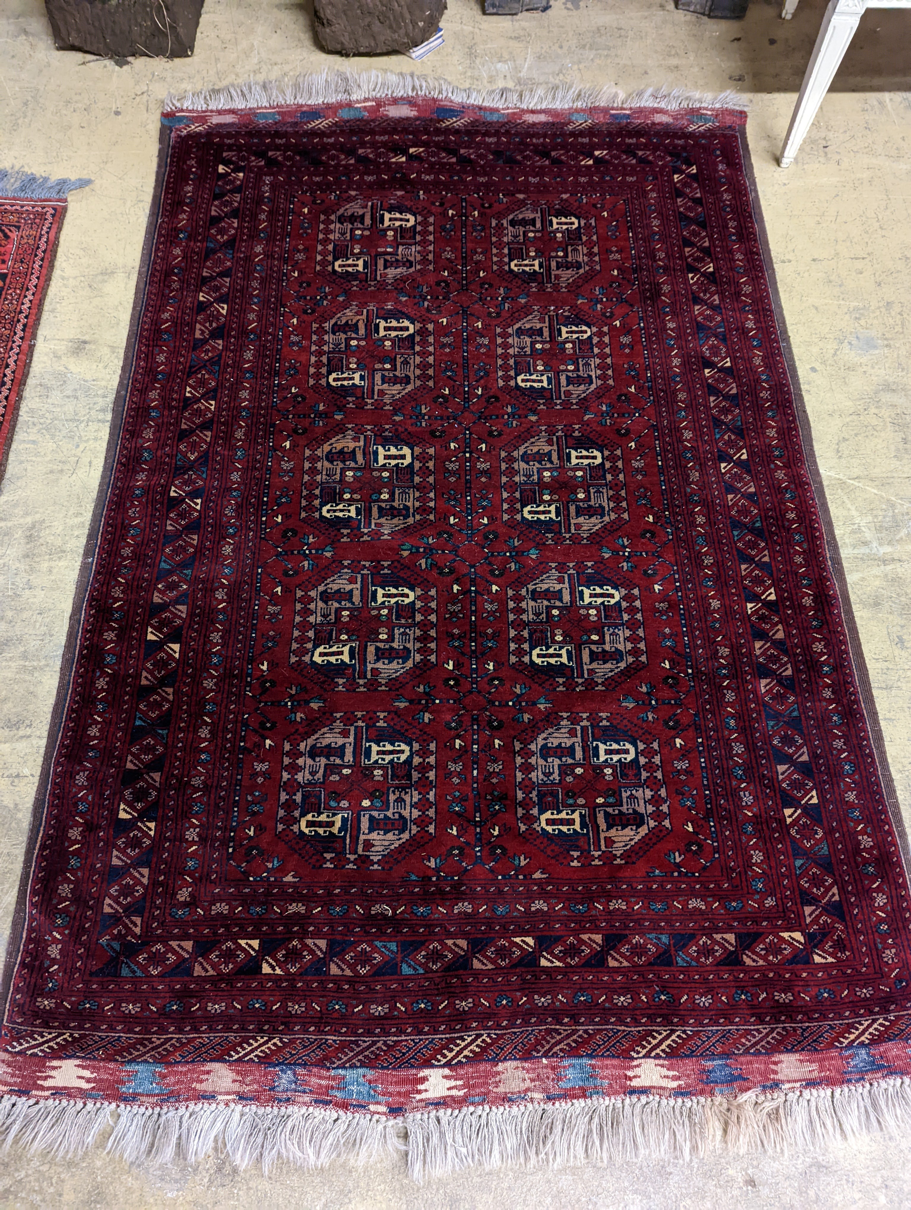 A Belouch red ground rug woven with octagonal motifs, 190 x 124 cms.
